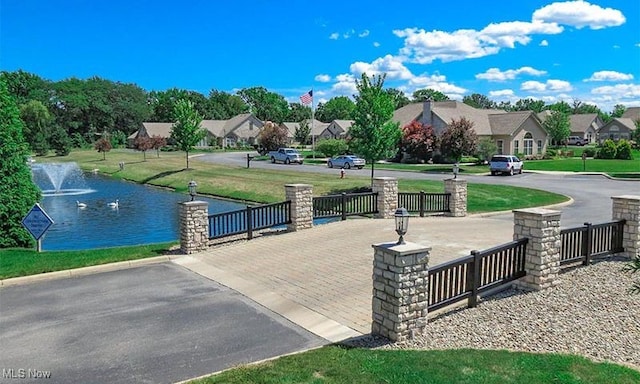 view of community with a yard, a water view, and a residential view