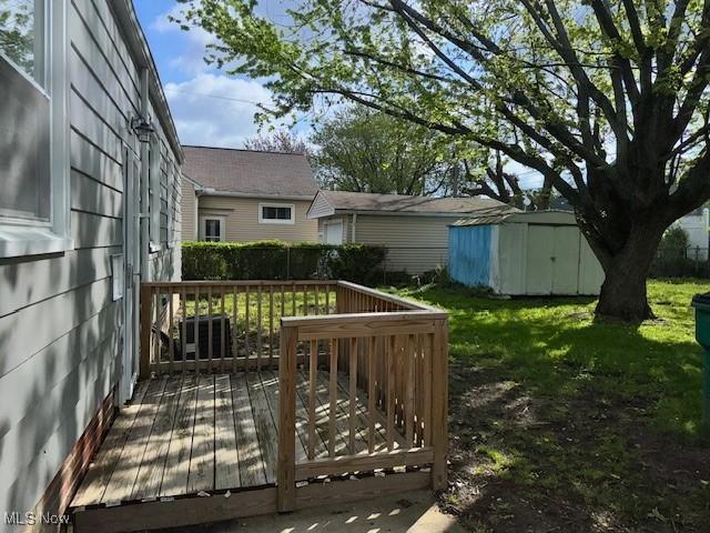 deck featuring fence, an outdoor structure, and a shed