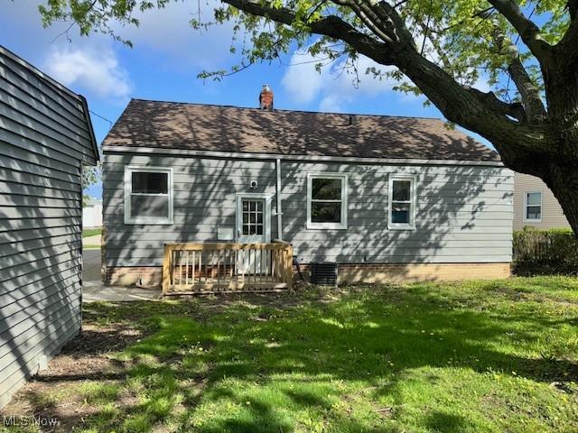 rear view of property with a lawn and a chimney