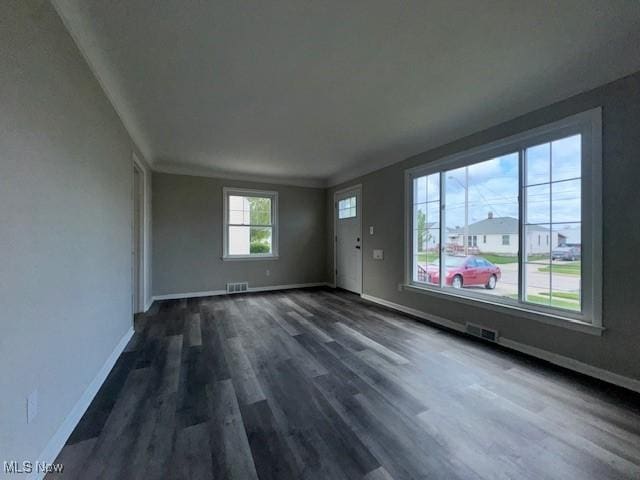 unfurnished living room with baseboards, dark wood-style floors, and visible vents