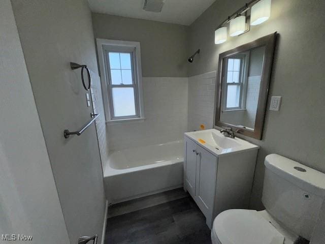 full bath with vanity, wood finished floors, toilet, and shower / washtub combination