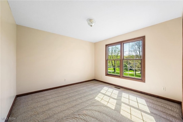 carpeted empty room with visible vents and baseboards