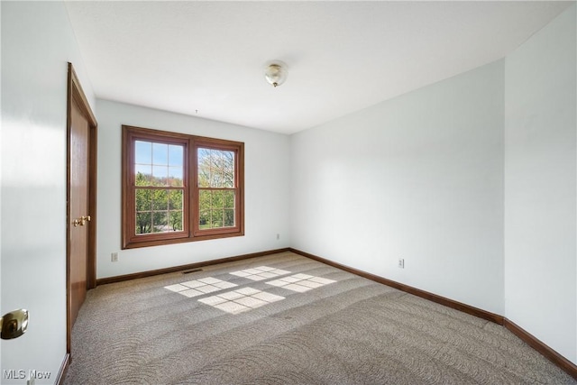 empty room with baseboards, carpet, and visible vents
