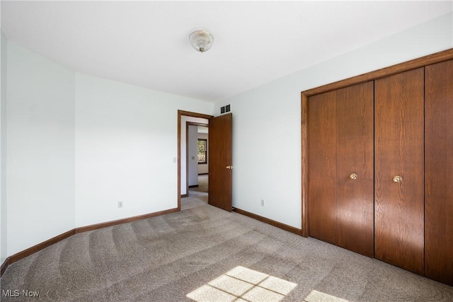 unfurnished bedroom with carpet floors, baseboards, a closet, and visible vents