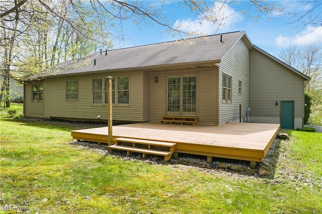 rear view of house featuring a yard and a deck