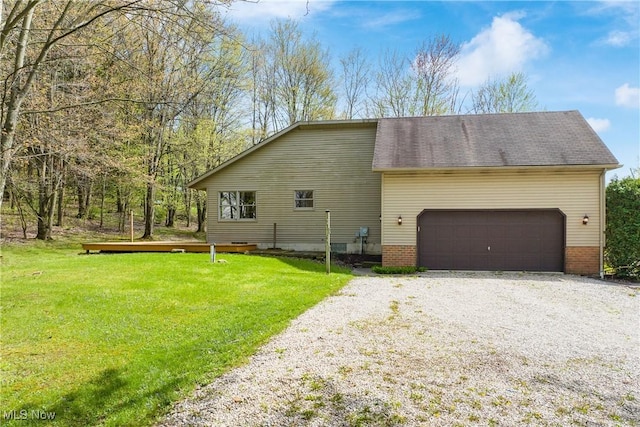 view of home's exterior featuring an attached garage, a yard, and driveway