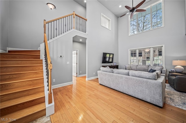 1432 Lake Vue Dr, Roaming Shores, OH 44085 - living room with ceiling fan, a high ceiling, light wood-style flooring, stairs, and baseboards