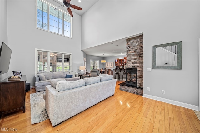 1432 Lake Vue Dr, Roaming Shores, OH 44085 - living area featuring ceiling fan, light wood-type flooring, baseboards, and a towering ceiling