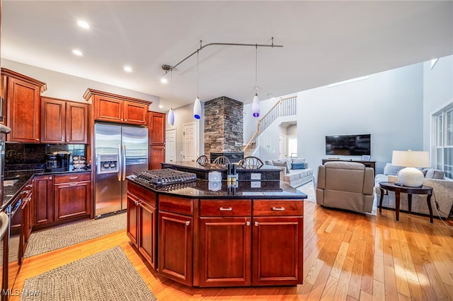 1432 Lake Vue Dr, Roaming Shores, OH 44085 - kitchen with backsplash, decorative light fixtures, light wood finished floors, reddish brown cabinets, and stainless steel appliances