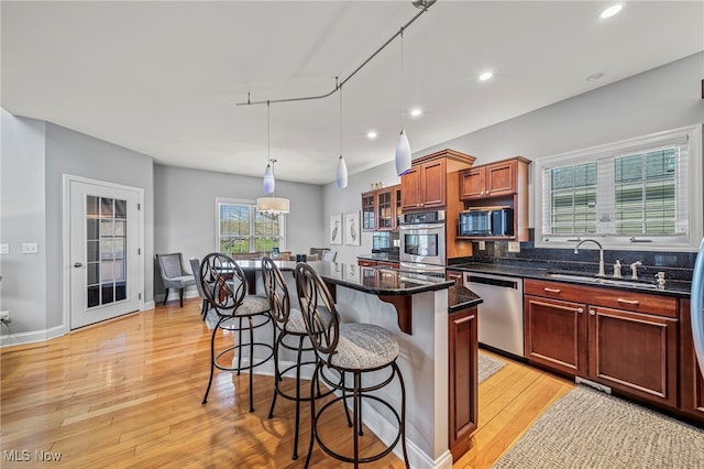 1432 Lake Vue Dr, Roaming Shores, OH 44085 - kitchen with a breakfast bar, light wood-style floors, a center island, a sink, and appliances with stainless steel finishes