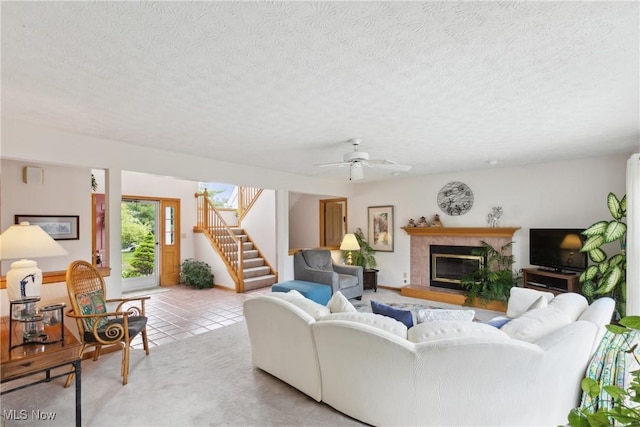 5420 Crystal Cove Cir, Stow, OH 44224 - living room featuring a tiled fireplace, a ceiling fan, stairs, and a textured ceiling