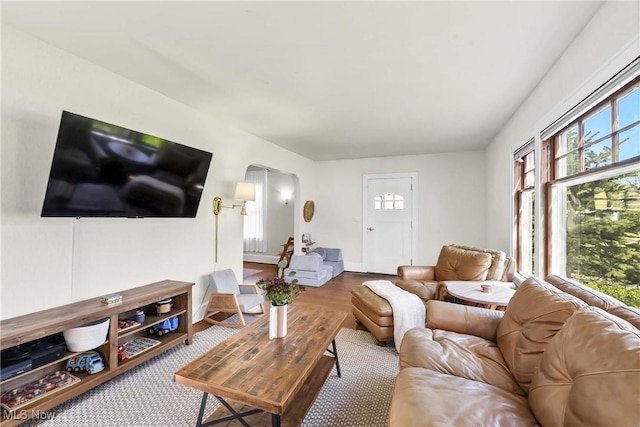 living area featuring arched walkways and baseboards