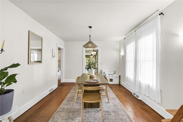 dining room featuring visible vents, baseboards, and wood finished floors