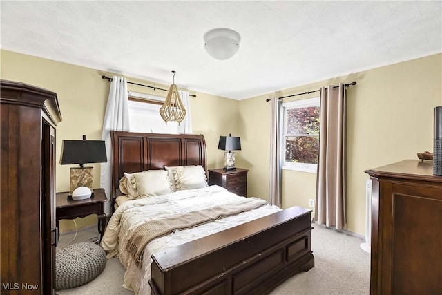 bedroom with baseboards and light colored carpet