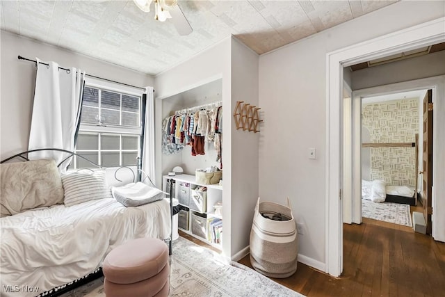 bedroom with baseboards, ceiling fan, and wood-type flooring