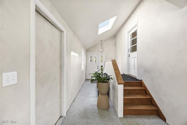 staircase with lofted ceiling with skylight