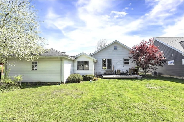 back of property with a lawn, fence, and a deck