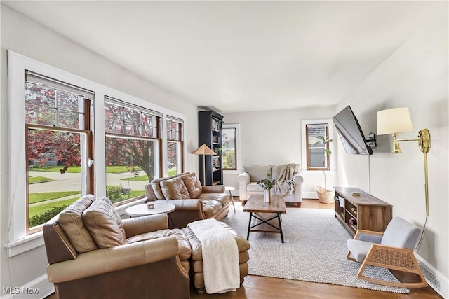 living room with plenty of natural light, wood finished floors, and visible vents