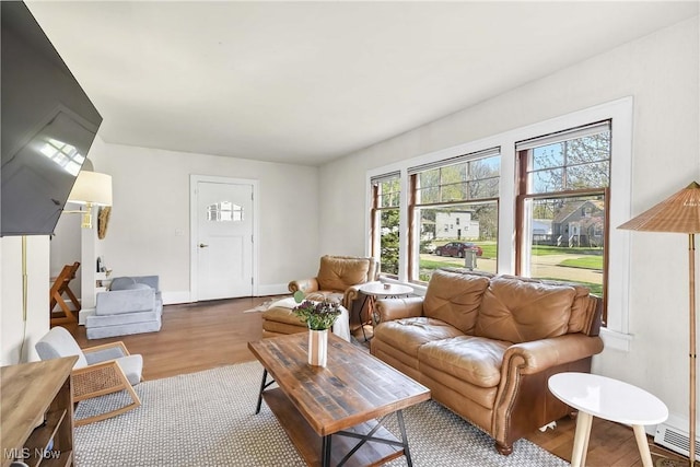 living room featuring visible vents, baseboards, and wood finished floors
