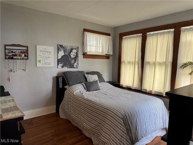 bedroom with baseboards and wood finished floors