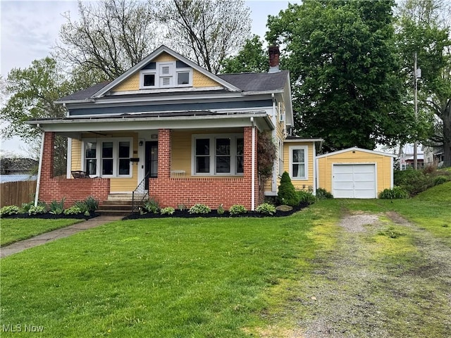 bungalow-style house with a porch, driveway, an outbuilding, and a front lawn