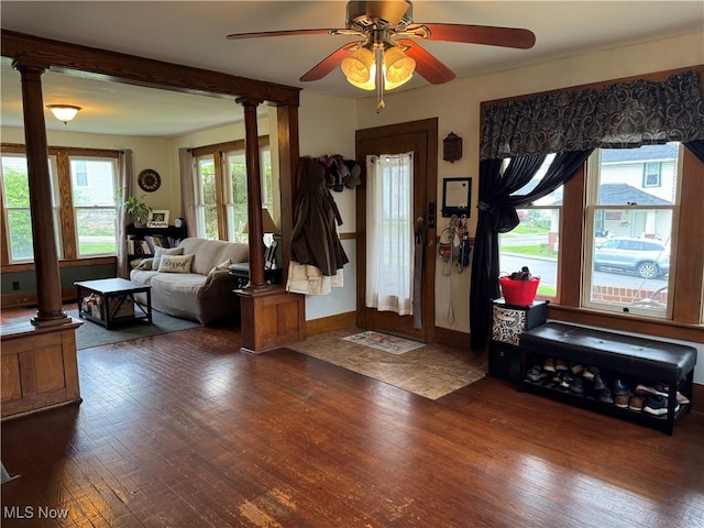 foyer entrance with baseboards, a ceiling fan, decorative columns, and wood finished floors