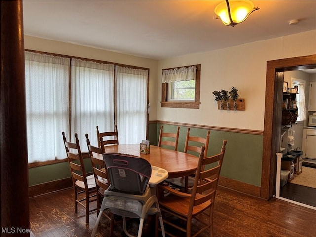 dining space with baseboards and wood finished floors