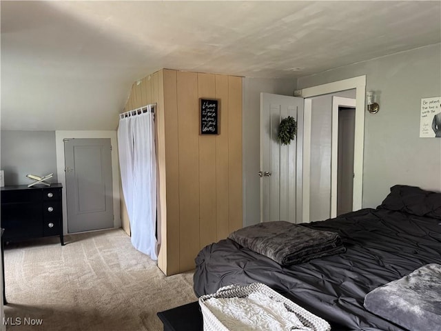 bedroom with light carpet and lofted ceiling