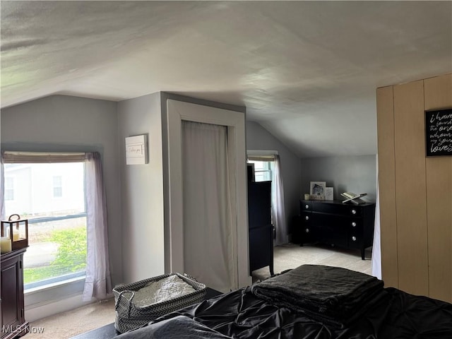 bedroom featuring light carpet and vaulted ceiling