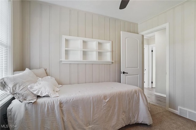 carpeted bedroom featuring a ceiling fan, baseboards, and visible vents