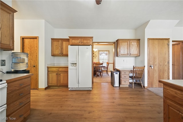 16544 Davis Dr, Calcutta, OH 43920 - kitchen featuring light countertops, white fridge with ice dispenser, brown cabinets, and wood finished floors