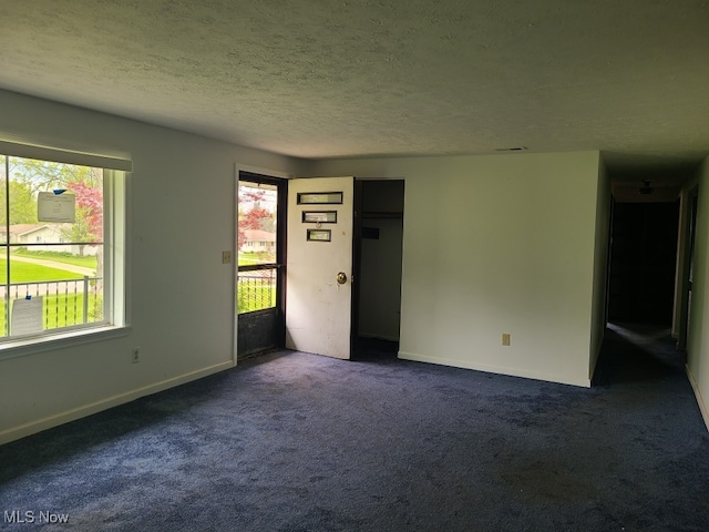 1485 Pike Pkwy, Streetsboro, OH 44241 - empty room with plenty of natural light, a textured ceiling, and dark colored carpet