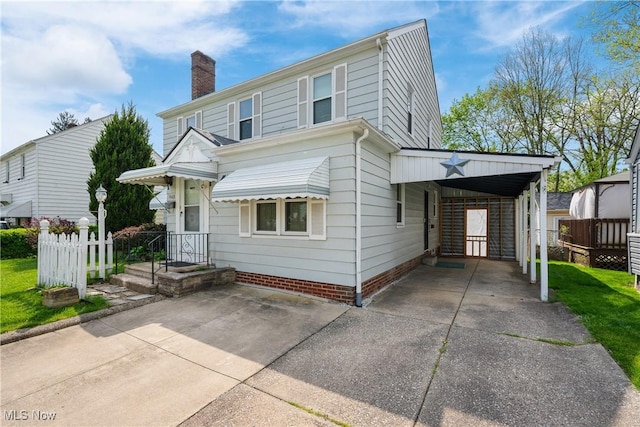 view of front of home featuring fence, a carport, a chimney, and driveway