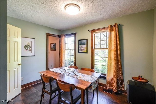 dining space with baseboards, dark wood finished floors, and a textured ceiling