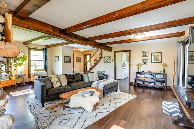 living room with stairs, baseboards, dark wood finished floors, and beam ceiling