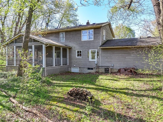 back of property featuring a sunroom, a yard, a chimney, and cooling unit