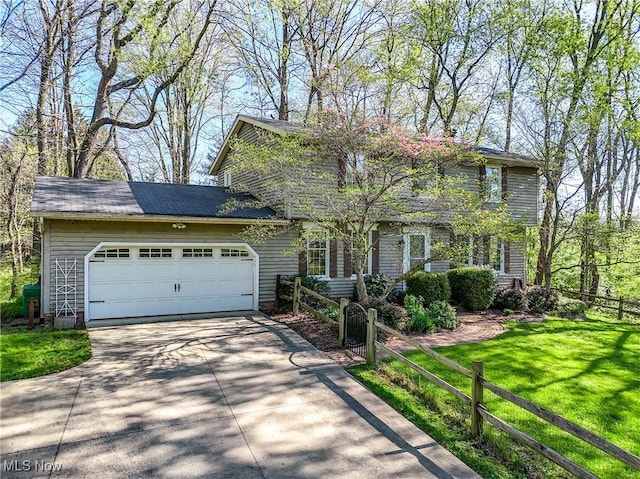 colonial home featuring an attached garage, a front lawn, fence, and driveway