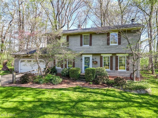 colonial-style house featuring a chimney, a front yard, a gate, fence, and an attached garage