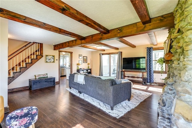 living area featuring wood-type flooring, beamed ceiling, baseboards, stairway, and a textured ceiling