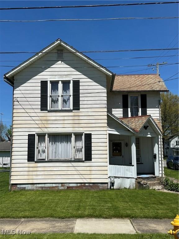 view of front facade featuring covered porch and a front yard