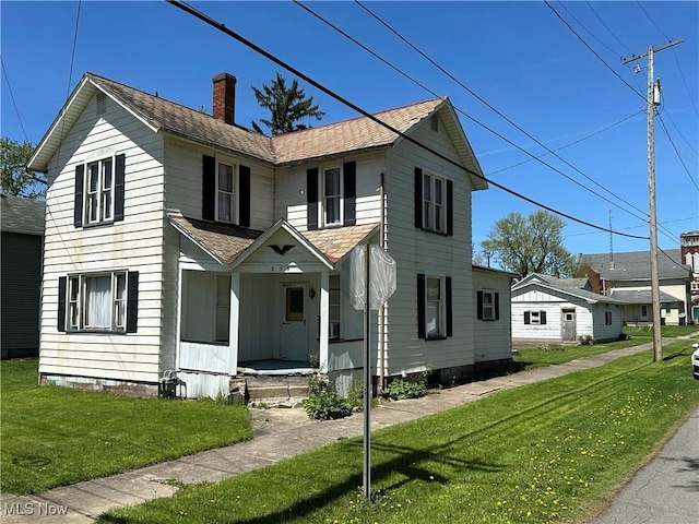 traditional home featuring a porch, a shingled roof, a front lawn, and a chimney