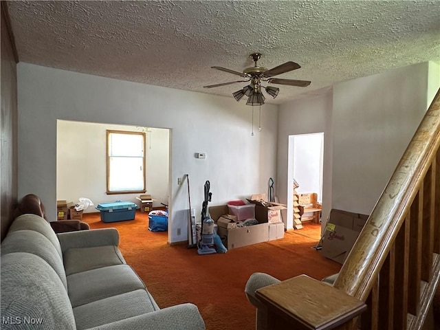 living room featuring carpet flooring, a ceiling fan, and a textured ceiling