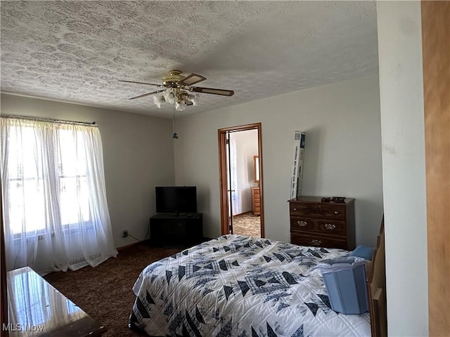 carpeted bedroom featuring a ceiling fan and a textured ceiling