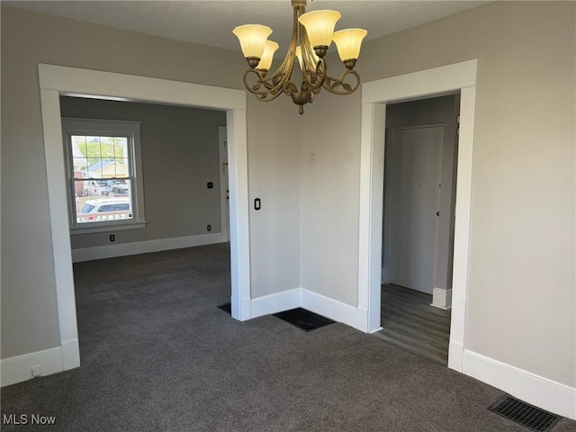 unfurnished dining area with carpet floors, baseboards, a chandelier, and visible vents