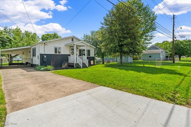 exterior space featuring fence, a carport, driveway, and a front yard