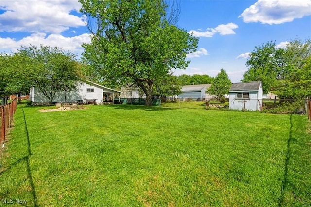 view of yard featuring a fenced backyard, an outdoor structure, and a storage shed