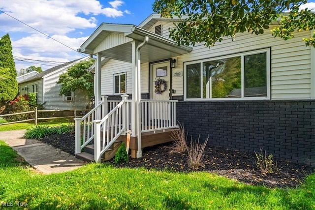 doorway to property with fence and brick siding