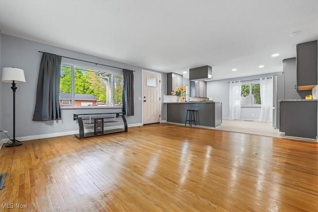 unfurnished living room featuring baseboards, recessed lighting, light wood finished floors, and visible vents