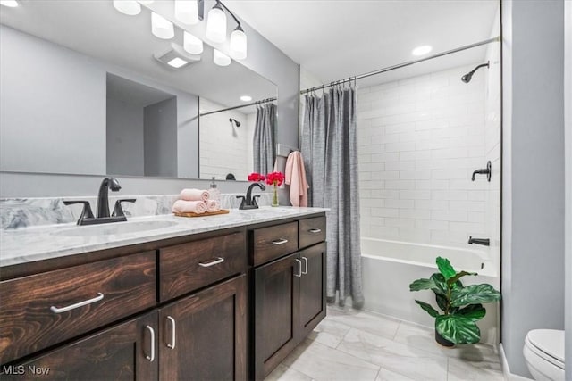 full bathroom featuring a sink, shower / bath combo with shower curtain, double vanity, and marble finish floor