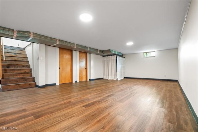 below grade area with recessed lighting, baseboards, wood finished floors, and stairway